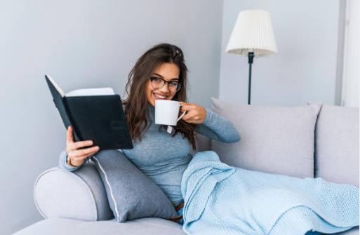 момиче, книга, диван и кафе