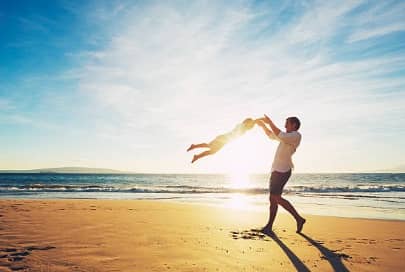 мъж и дете играят на плаж под слънцето - красота и здраве